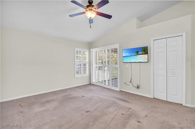 interior space with lofted ceiling, light carpet, and ceiling fan