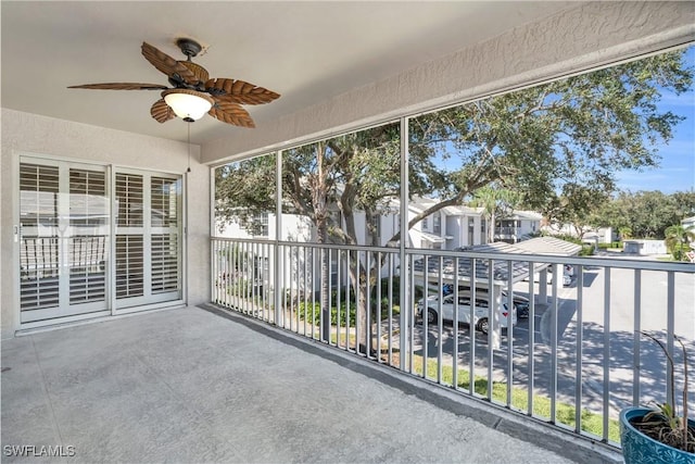 unfurnished sunroom with ceiling fan