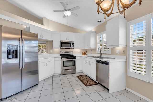 kitchen featuring vaulted ceiling, white cabinetry, appliances with stainless steel finishes, and plenty of natural light