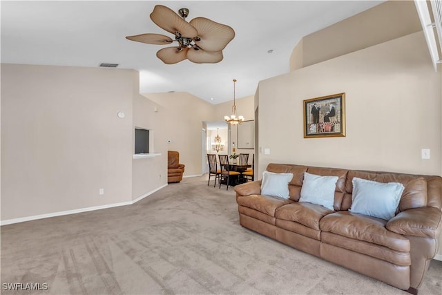 living room featuring vaulted ceiling, ceiling fan with notable chandelier, and light colored carpet