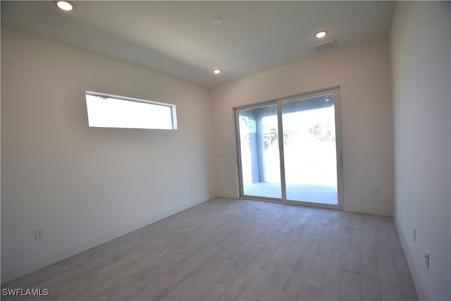 spare room featuring a wealth of natural light and light wood-type flooring