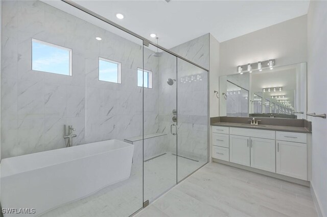 bathroom featuring a freestanding tub, vanity, a marble finish shower, and wood finished floors