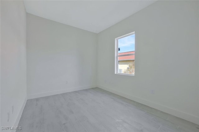 empty room featuring light wood finished floors and baseboards