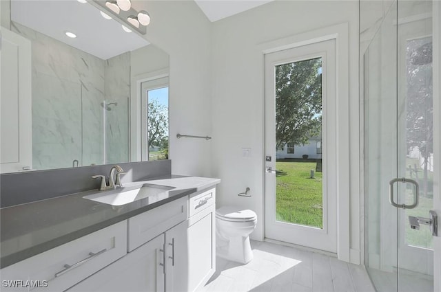 full bathroom featuring toilet, a marble finish shower, and vanity