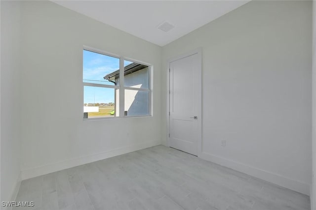 unfurnished room with light wood finished floors and baseboards