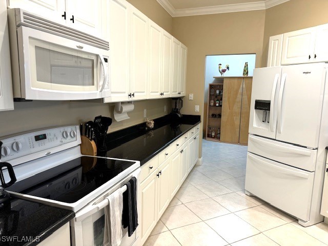 kitchen featuring crown molding, white cabinetry, and white appliances