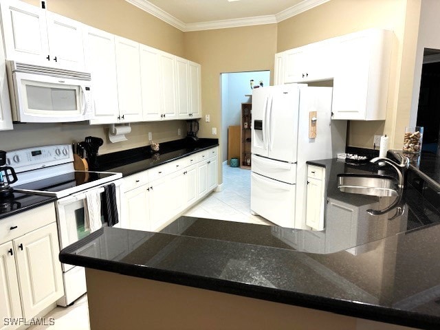 kitchen with white appliances, ornamental molding, and white cabinets