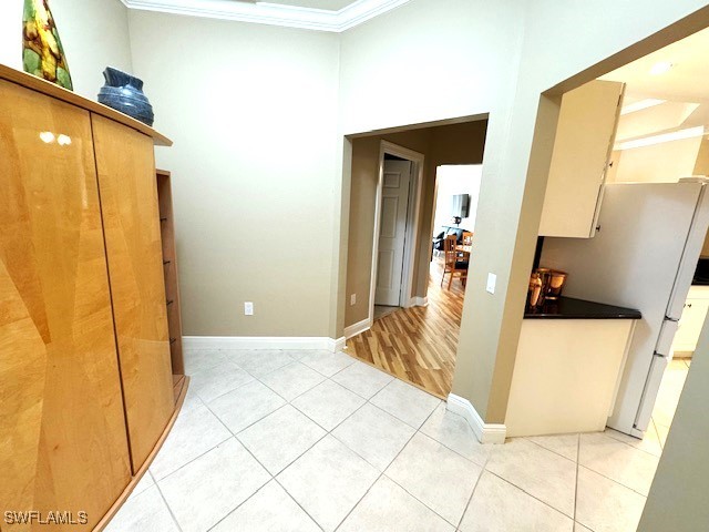 hallway featuring crown molding and light tile patterned floors