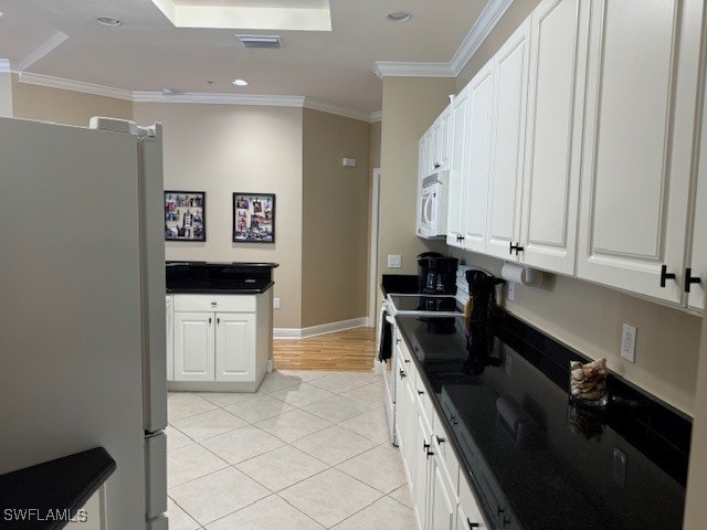 kitchen featuring light tile patterned flooring, refrigerator, range, white cabinets, and ornamental molding