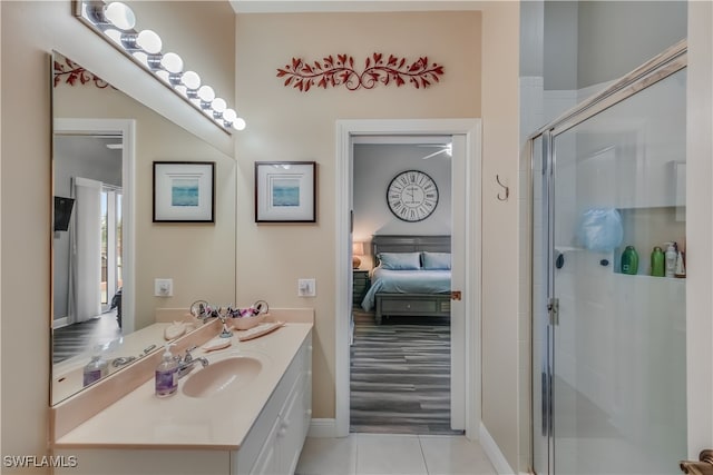 bathroom featuring vanity, a shower with shower door, and tile patterned flooring