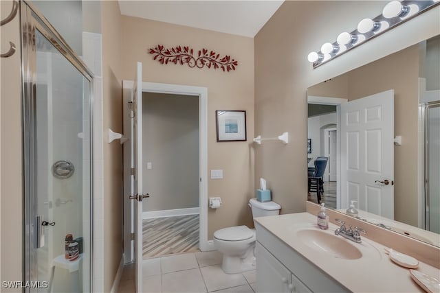 bathroom featuring vanity, tile patterned flooring, toilet, and an enclosed shower