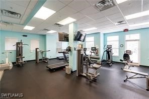 exercise room with a drop ceiling and a healthy amount of sunlight