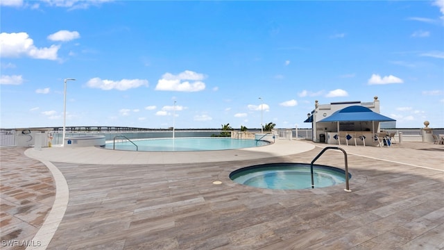 view of swimming pool with a hot tub and a patio