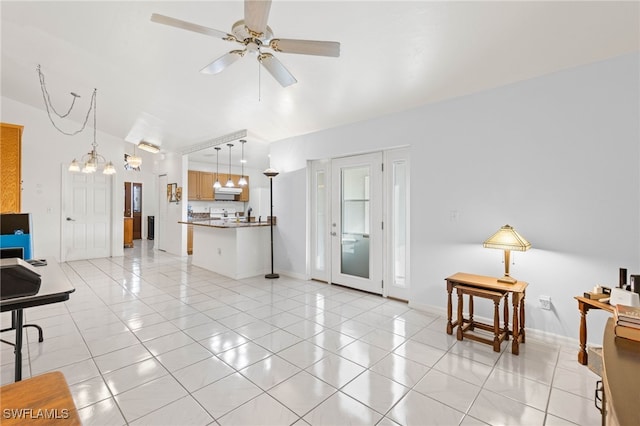 tiled living room featuring ceiling fan with notable chandelier