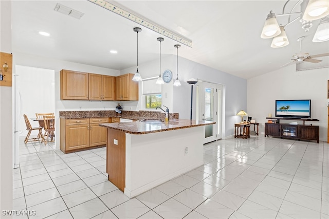 kitchen featuring sink, hanging light fixtures, ceiling fan, lofted ceiling, and dark stone counters