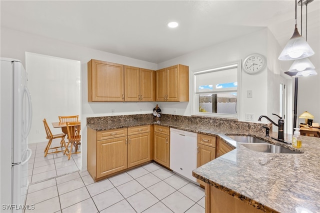 kitchen with hanging light fixtures, dark stone counters, sink, light tile patterned floors, and white appliances