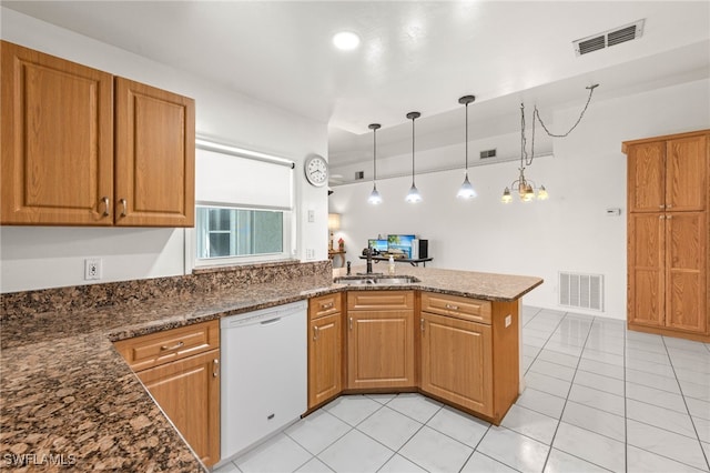 kitchen featuring kitchen peninsula, hanging light fixtures, white dishwasher, dark stone counters, and sink