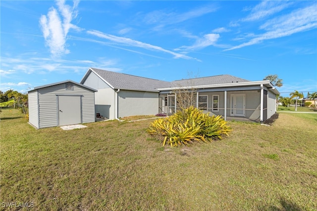 back of house featuring a storage unit, a yard, and a sunroom