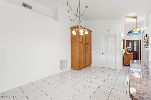 unfurnished dining area with vaulted ceiling, an inviting chandelier, and light tile patterned floors