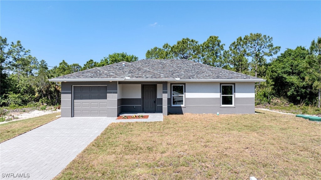 ranch-style house with a garage and a front lawn