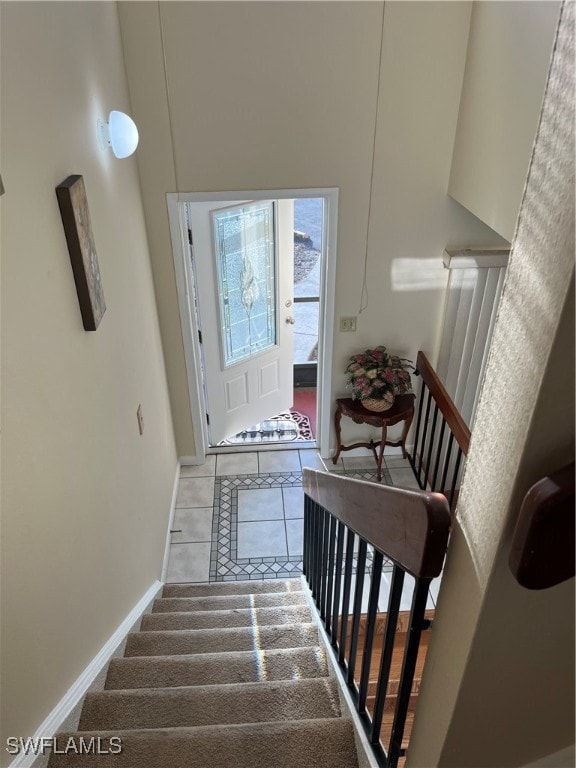 stairs featuring a high ceiling and tile patterned flooring