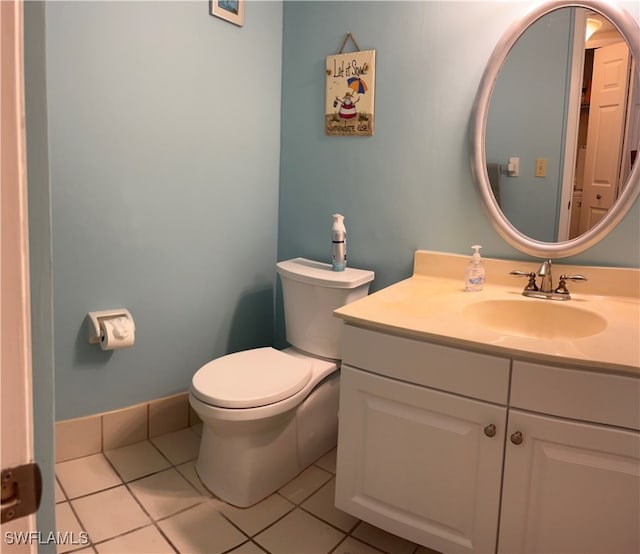 bathroom with toilet, vanity, and tile patterned floors