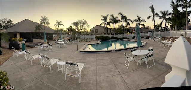 pool at dusk with a patio area