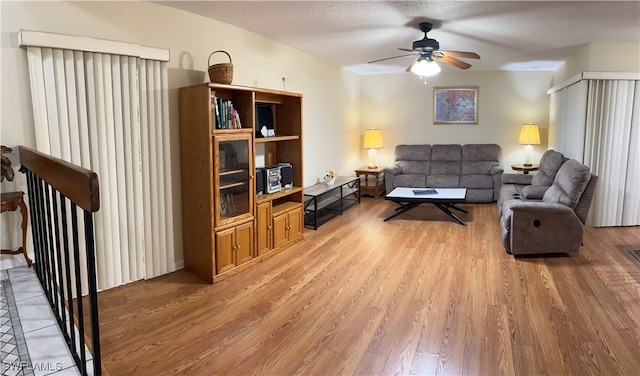 living room featuring hardwood / wood-style floors, a textured ceiling, and ceiling fan