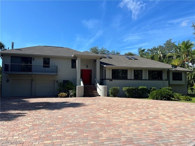 view of front of home featuring a garage and a balcony