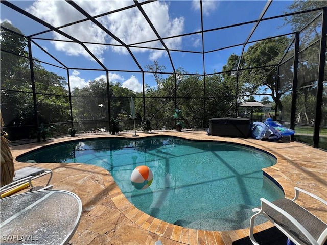 view of swimming pool with glass enclosure and a patio area