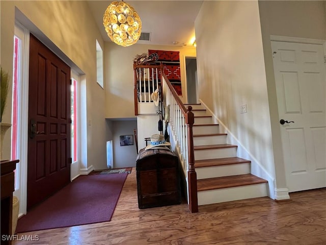 foyer entrance featuring hardwood / wood-style floors and an inviting chandelier