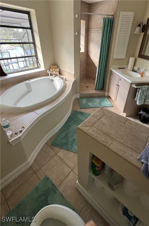 bathroom with vanity, tile patterned flooring, and plus walk in shower