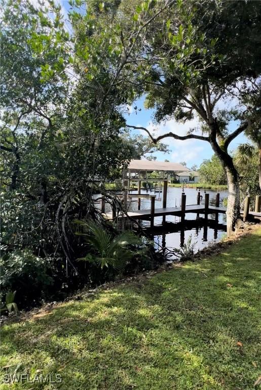 dock area featuring a water view and a lawn