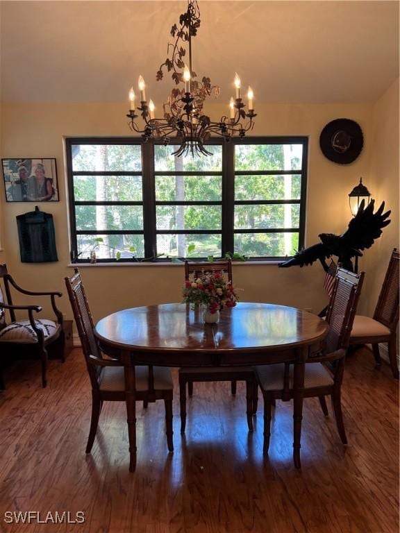 dining space with lofted ceiling, a notable chandelier, and wood finished floors