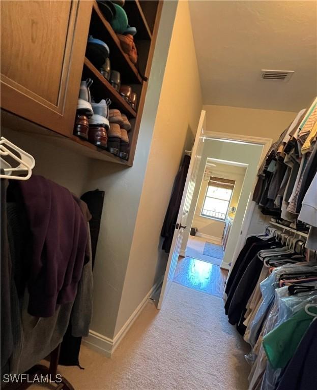 spacious closet featuring visible vents and light colored carpet