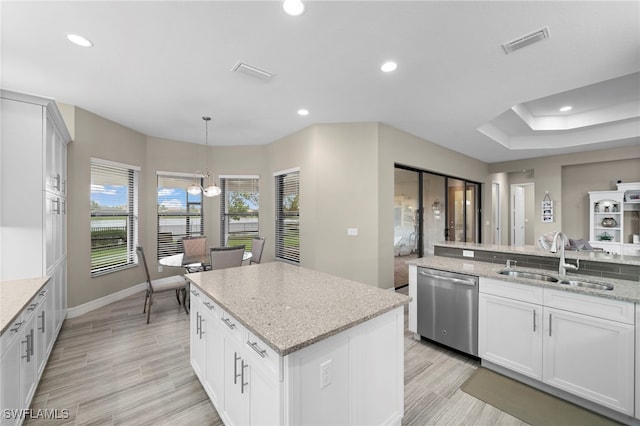 kitchen featuring sink, white cabinetry, a center island, decorative light fixtures, and stainless steel dishwasher