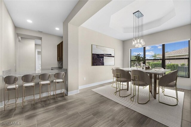 4365 Caldera Cir, Naples, FL 34119 - dining room with baseboards, recessed lighting, a chandelier, a tray ceiling, and light wood-style flooring