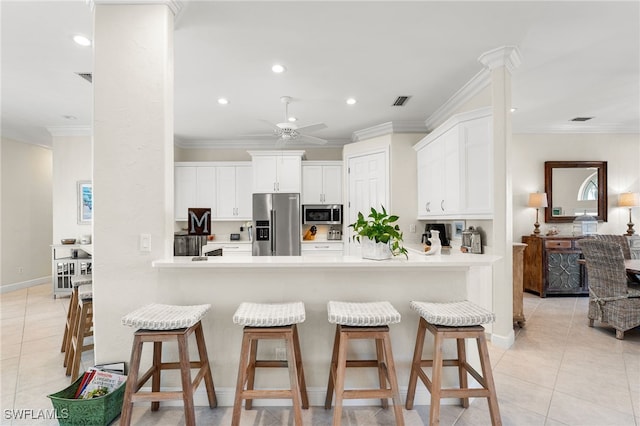 kitchen with white cabinetry, ornamental molding, appliances with stainless steel finishes, and kitchen peninsula