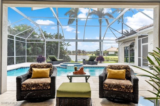 view of pool with an in ground hot tub, a water view, a patio area, and glass enclosure