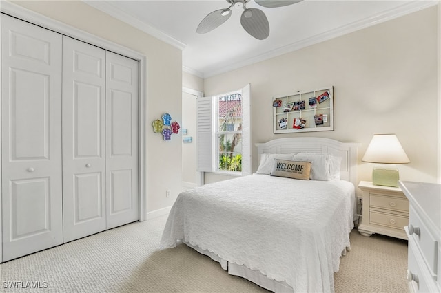 carpeted bedroom with ceiling fan, ornamental molding, and a closet