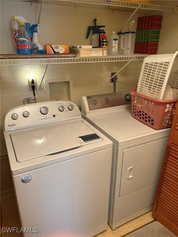 washroom with independent washer and dryer and tile patterned floors