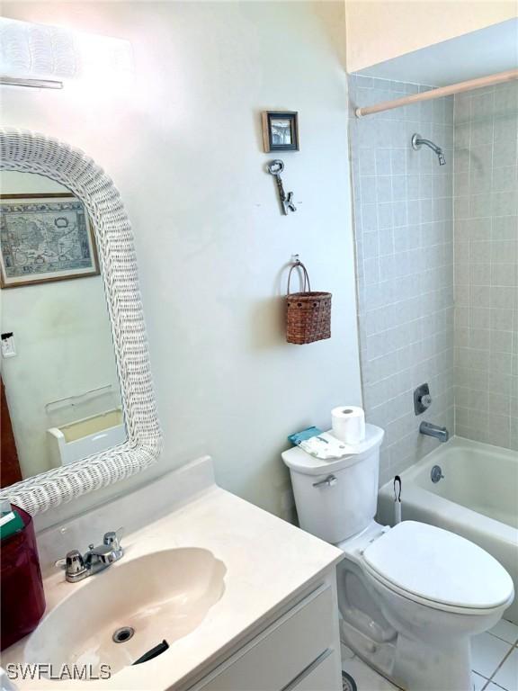 full bathroom with toilet, tile patterned floors, vanity, and tiled shower / bath