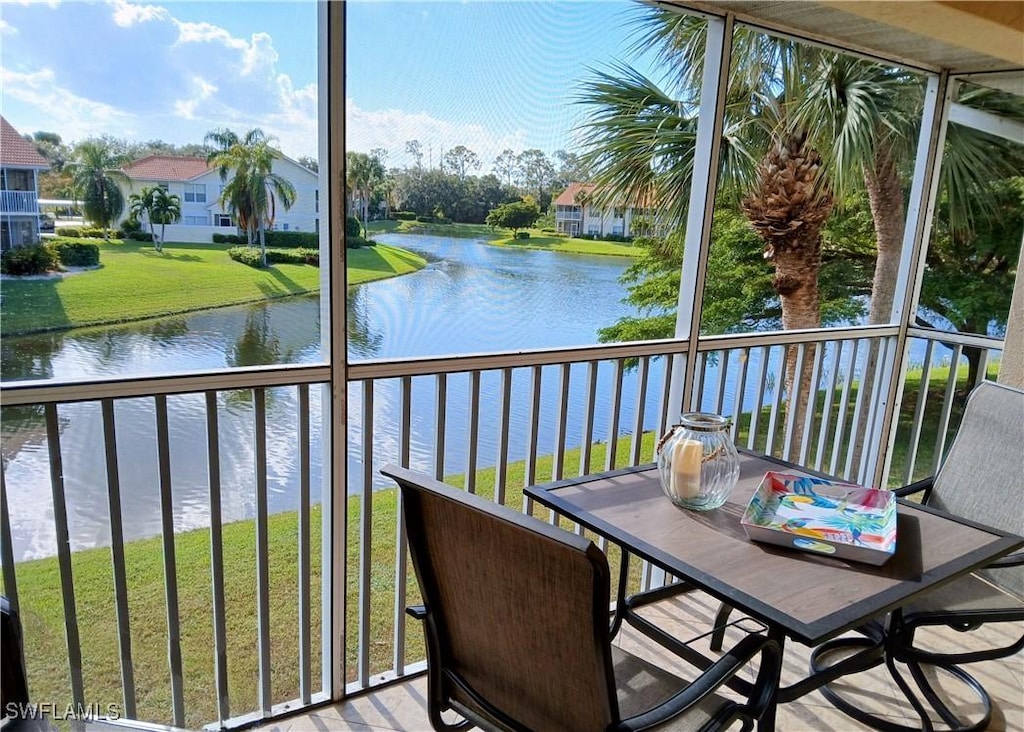 sunroom featuring a water view