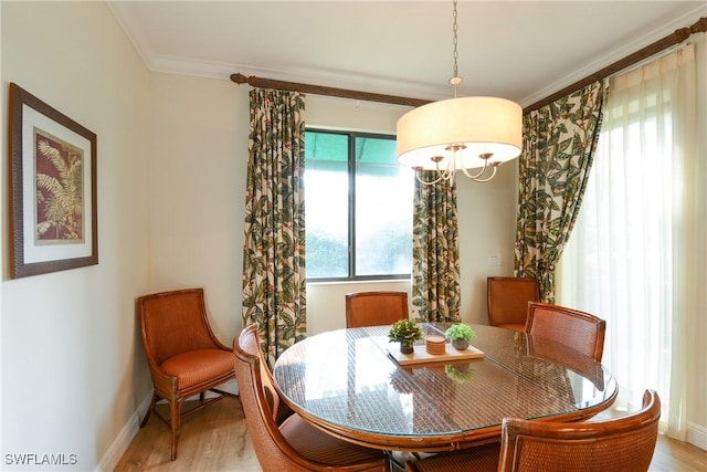 dining space featuring ornamental molding and light hardwood / wood-style floors