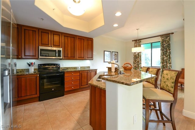 kitchen featuring black / electric stove, dark stone countertops, sink, hanging light fixtures, and a raised ceiling