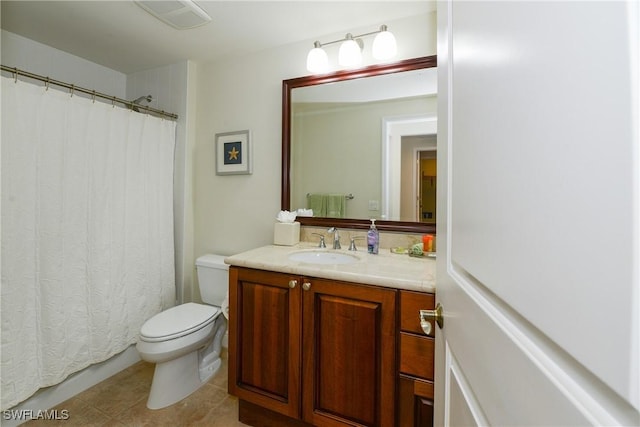 bathroom with toilet, vanity, and tile patterned flooring