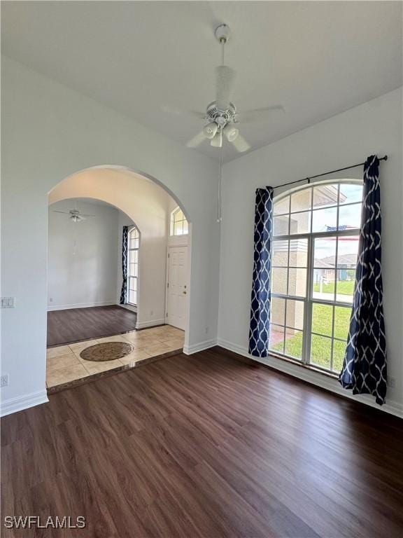 spare room with dark hardwood / wood-style flooring and ceiling fan