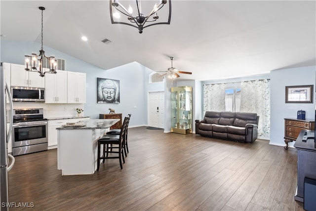 kitchen featuring lofted ceiling, pendant lighting, white cabinets, and stainless steel appliances