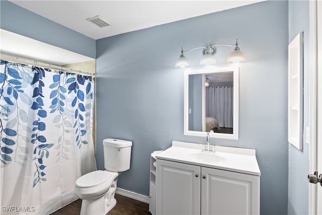 bathroom featuring vanity, curtained shower, and toilet