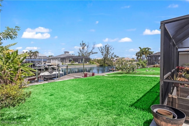 view of yard featuring a water view, glass enclosure, and a dock